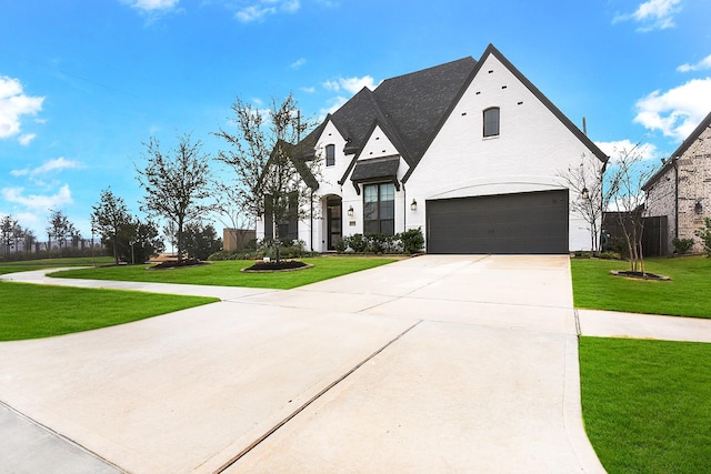 french country style house with a front yard and a garage