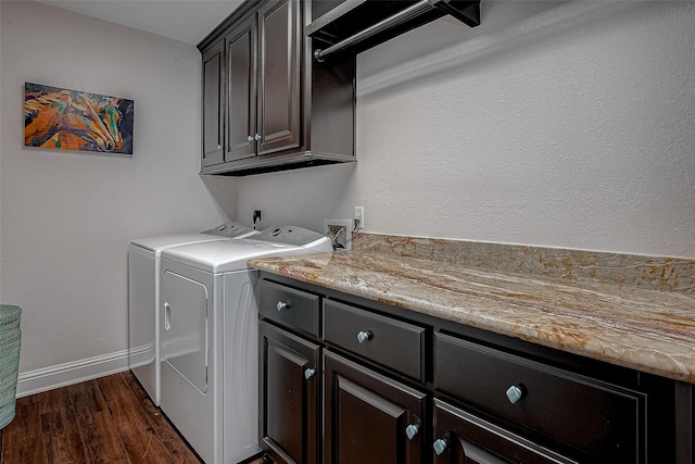 clothes washing area with washing machine and dryer, cabinets, and dark hardwood / wood-style floors