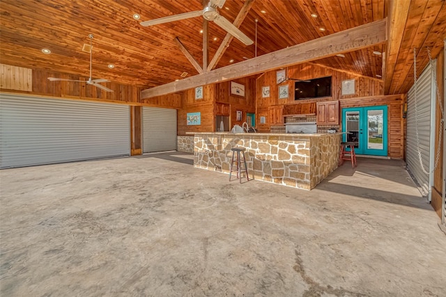 interior space featuring wooden walls, ceiling fan, and wood ceiling