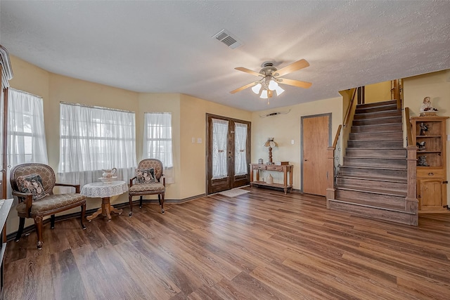 foyer with visible vents, a ceiling fan, wood finished floors, stairs, and a textured ceiling