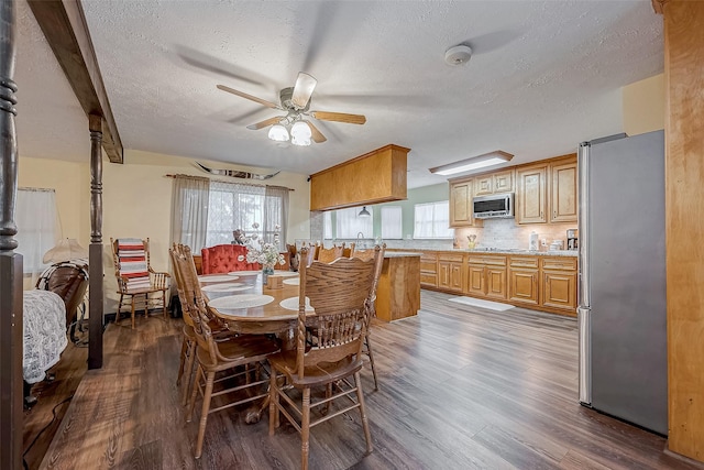 dining room with ceiling fan, a textured ceiling, and wood finished floors