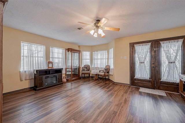 entrance foyer with a textured ceiling, french doors, dark wood-type flooring, and visible vents