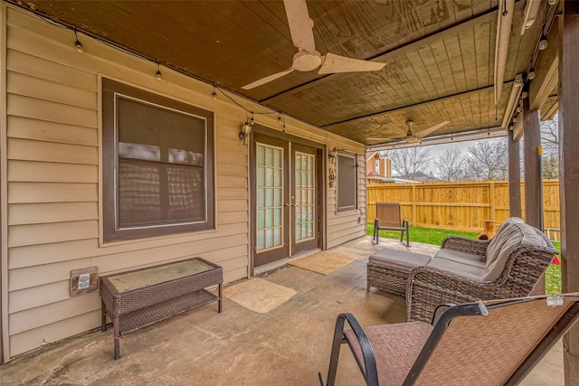 view of patio / terrace with fence, a ceiling fan, and french doors