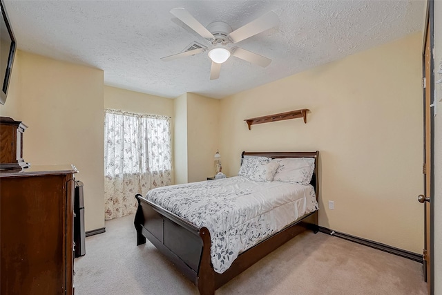 bedroom featuring a ceiling fan, light colored carpet, a textured ceiling, and baseboards