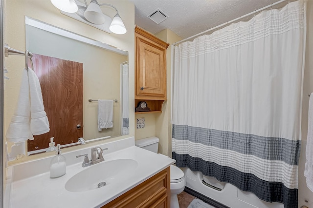 bathroom featuring a textured ceiling, toilet, visible vents, and vanity