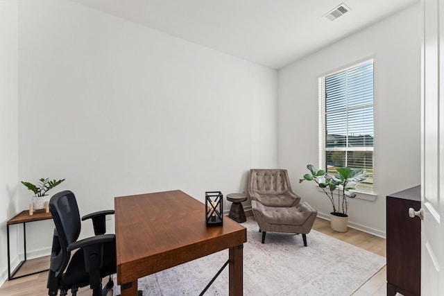 office with light wood-type flooring, baseboards, and visible vents