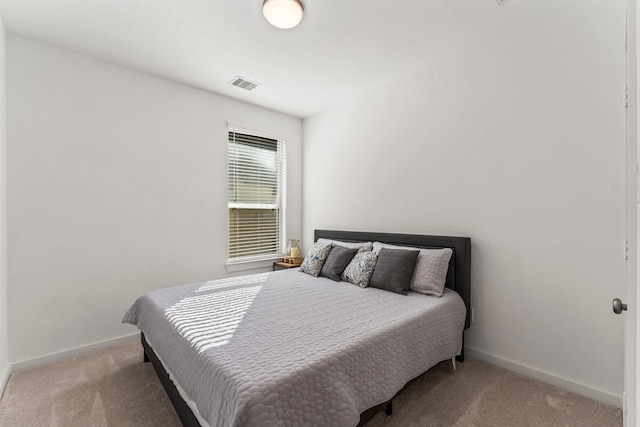 bedroom featuring baseboards, visible vents, and light colored carpet