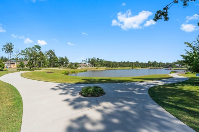 view of community with a water view and a lawn