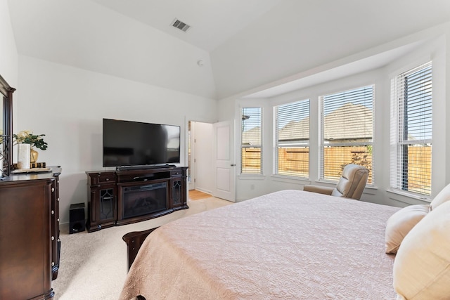 bedroom featuring light colored carpet, visible vents, and lofted ceiling