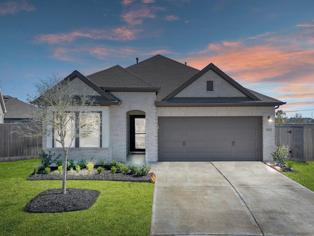 view of front of property featuring a garage and a lawn