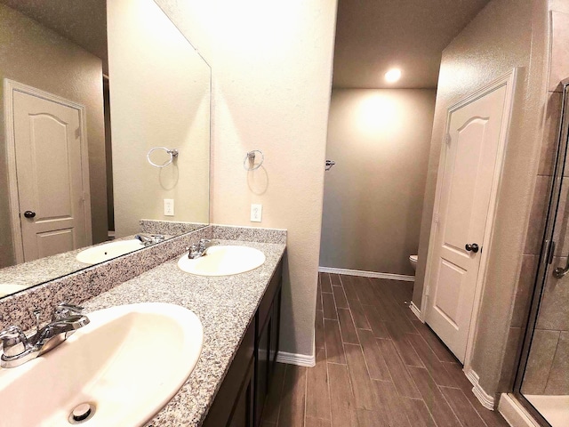 24827 Colony Meadow Trl, Houston, TX 77336 - full bath with wood finished floors, baseboards, double vanity, toilet, and a stall shower