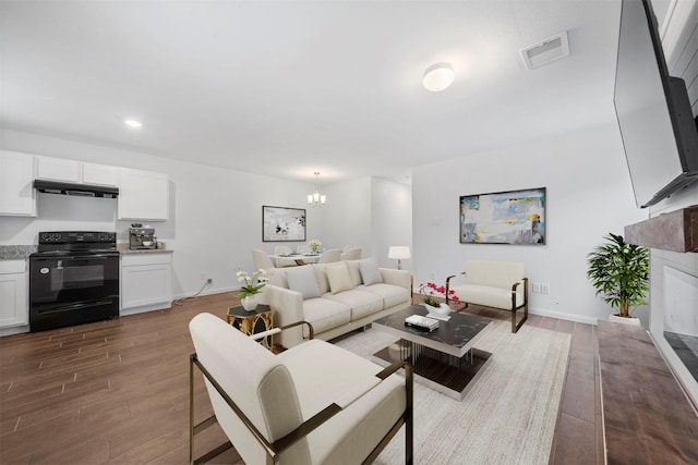 living room with a chandelier and dark hardwood / wood-style floors