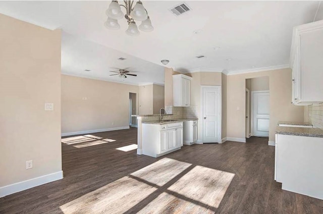 kitchen featuring a sink, visible vents, white cabinets, open floor plan, and decorative backsplash