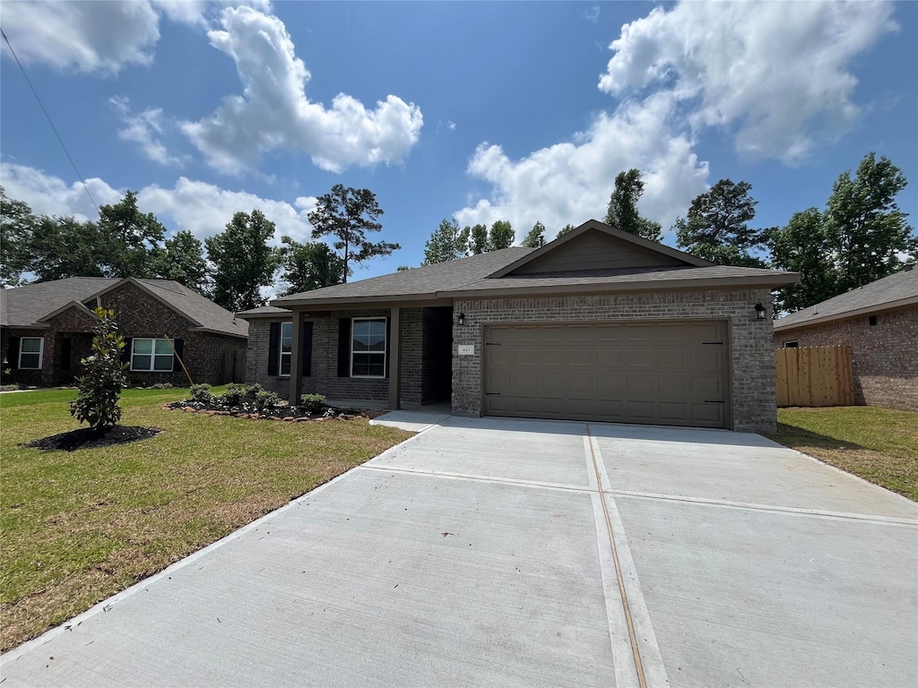 ranch-style house with a front lawn, driveway, fence, a garage, and brick siding