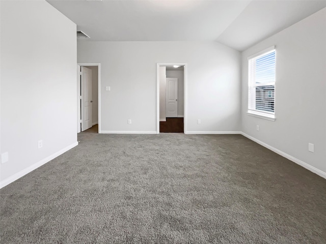 unfurnished bedroom featuring lofted ceiling, baseboards, visible vents, and dark carpet
