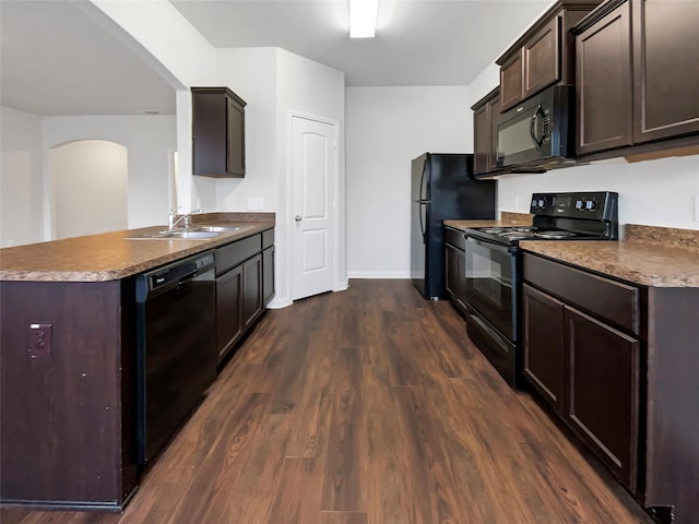 kitchen featuring dark wood-style flooring, a sink, black appliances, and dark brown cabinets