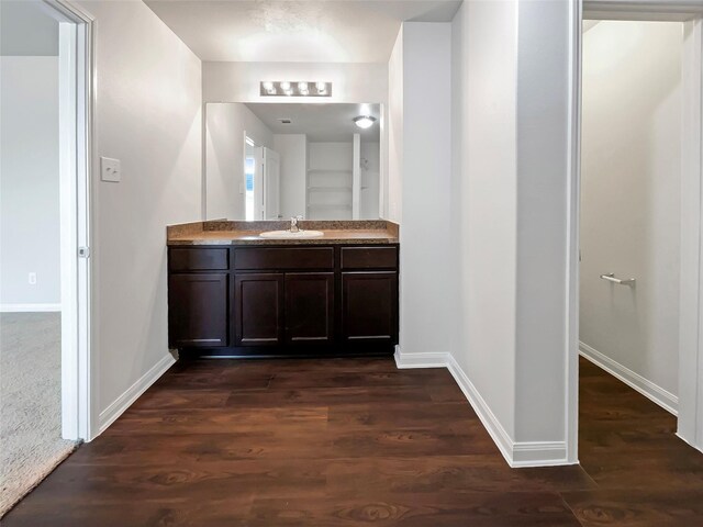 bathroom featuring wood finished floors, vanity, and baseboards