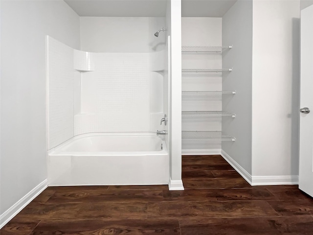 bathroom featuring shower / washtub combination, baseboards, and wood finished floors