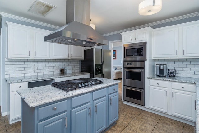 kitchen featuring appliances with stainless steel finishes, a kitchen island, white cabinetry, and island exhaust hood