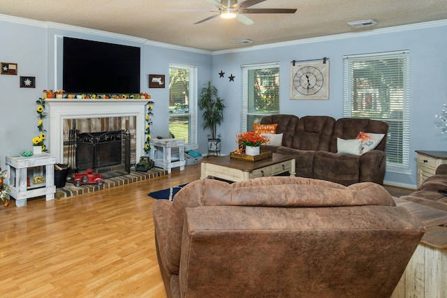 living room featuring ornamental molding, hardwood / wood-style flooring, and a brick fireplace