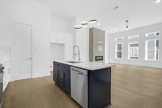 kitchen with white cabinetry, a kitchen island with sink, sink, dishwasher, and pendant lighting