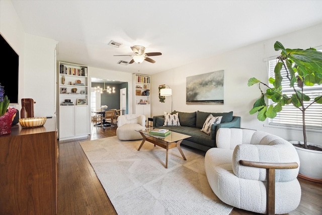 living room featuring hardwood / wood-style floors and ceiling fan with notable chandelier