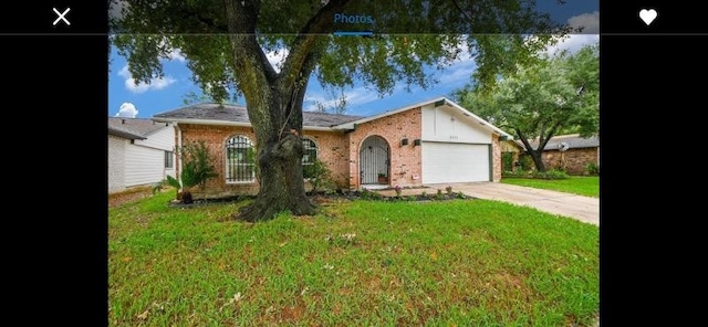 ranch-style house featuring a garage and a front lawn