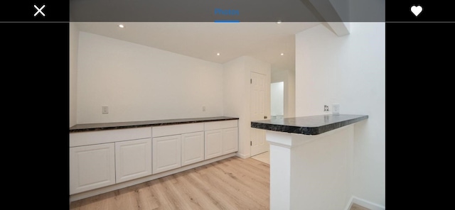 kitchen featuring light wood-type flooring, white cabinetry, and kitchen peninsula