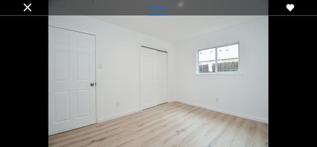 unfurnished bedroom with light hardwood / wood-style floors and a closet