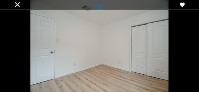 unfurnished bedroom featuring light wood-type flooring and a closet