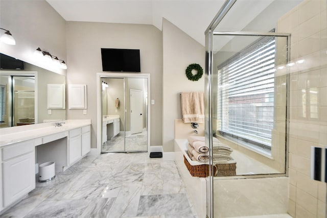 full bath with a stall shower, marble finish floor, a garden tub, vaulted ceiling, and vanity