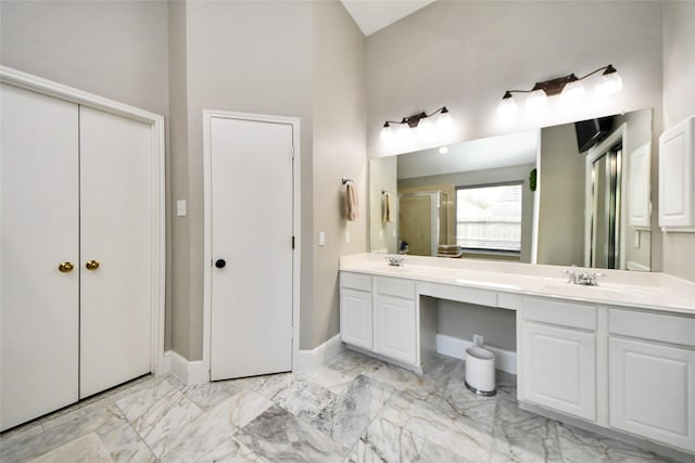 bathroom with a stall shower, marble finish floor, and a sink