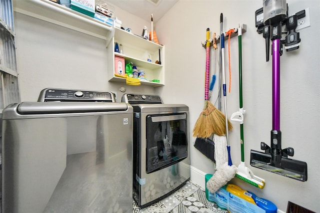 clothes washing area with laundry area, baseboards, and separate washer and dryer