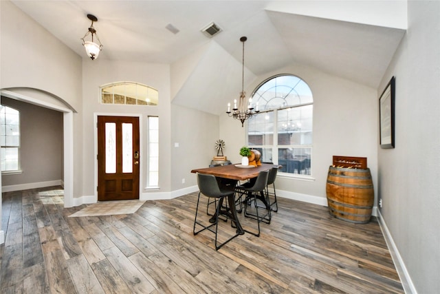 entryway with a wealth of natural light, dark wood-type flooring, vaulted ceiling, and visible vents