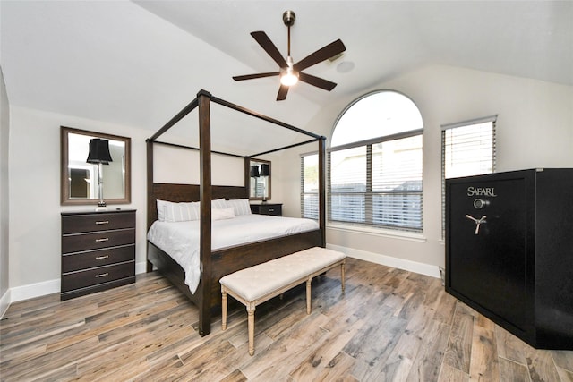 bedroom with vaulted ceiling, wood finished floors, and baseboards