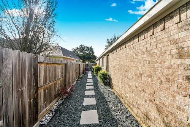 view of property exterior with brick siding and fence