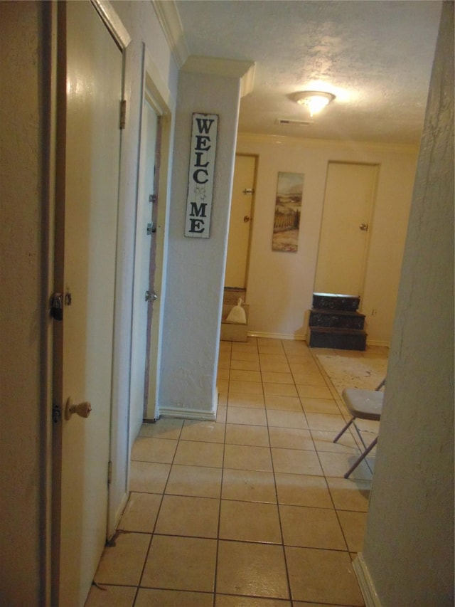 hallway featuring light tile patterned flooring and ornamental molding