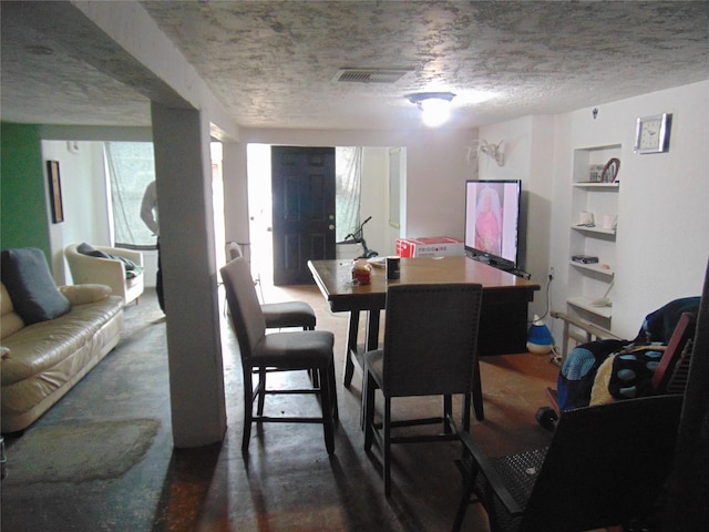 dining area featuring built in features and a textured ceiling