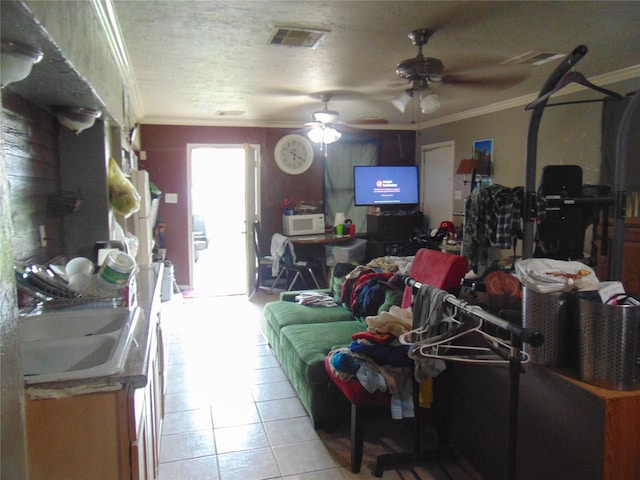 living room featuring sink, ornamental molding, light tile patterned flooring, and ceiling fan