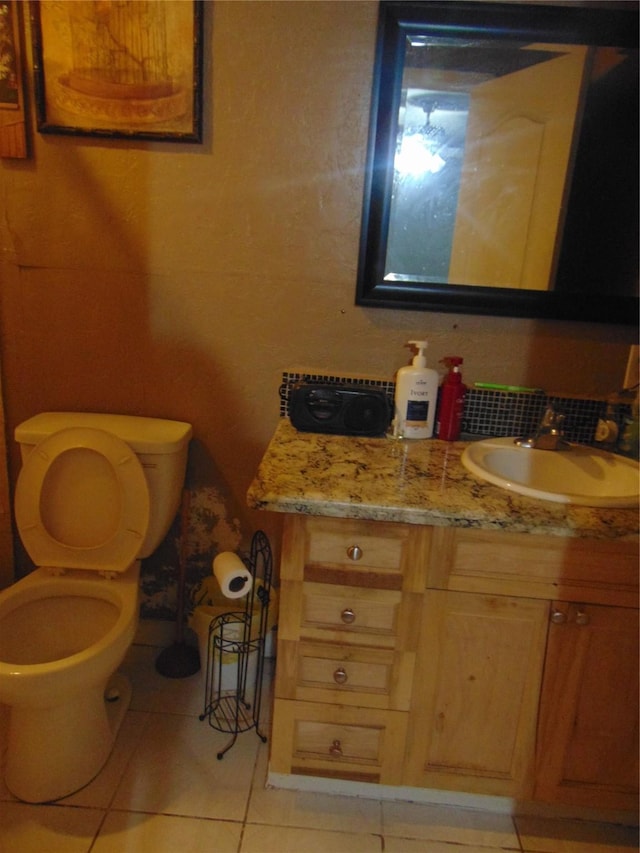 bathroom featuring toilet, vanity, and tile patterned flooring