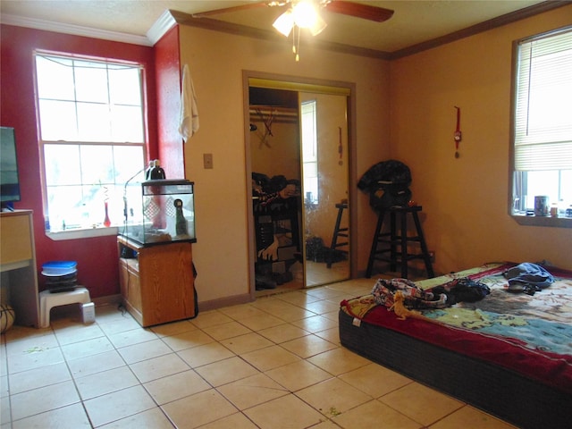 tiled bedroom featuring a closet, crown molding, and ceiling fan