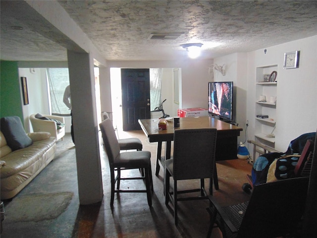 dining room with built in shelves and a textured ceiling