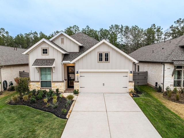 view of front of house with driveway, roof with shingles, a front yard, and board and batten siding