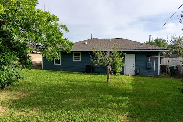 back of property with a lawn and central air condition unit