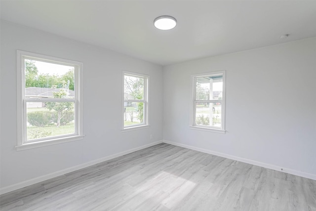 unfurnished room featuring a healthy amount of sunlight and light hardwood / wood-style flooring