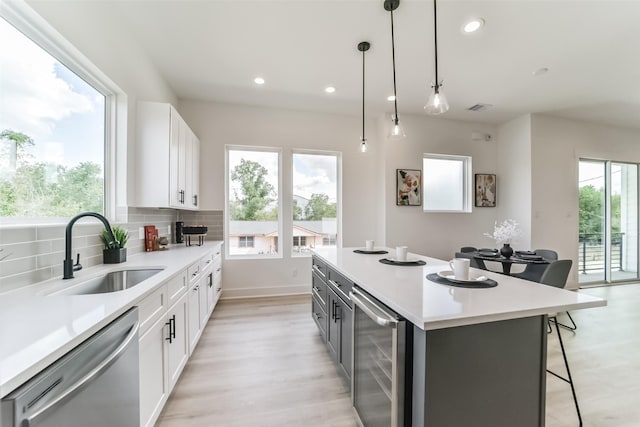515 Egan St, Houston, TX 77020 - kitchen featuring wine cooler, dishwasher, a sink, light wood-type flooring, and recessed lighting