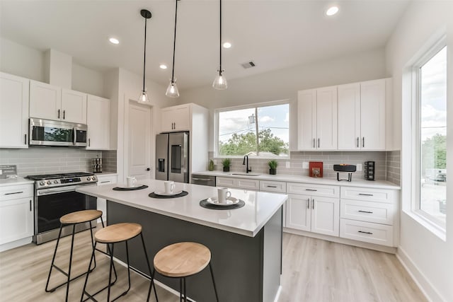 515 Egan St, Houston, TX 77020 - kitchen featuring appliances with stainless steel finishes, a sink, decorative backsplash, a center island, and a kitchen bar