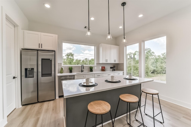 515 Egan St, Houston, TX 77020 - kitchen with stainless steel appliances, a sink, backsplash, a kitchen bar, and light countertops