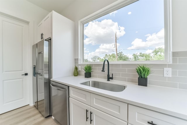 515 Egan St, Houston, TX 77020 - kitchen with appliances with stainless steel finishes, a sink, white cabinets, and decorative backsplash