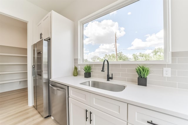 515 Egan St, Houston, TX 77020 - kitchen with stainless steel appliances, a sink, white cabinets, and light countertops